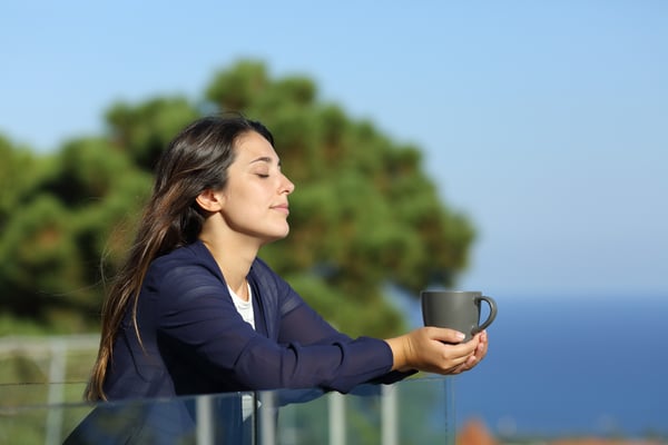 A lady is relaxing with harbor view and a cup of coffee 