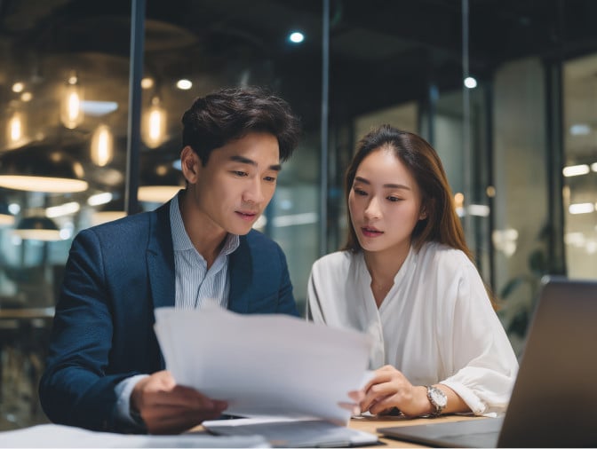 man and woman looking at documents